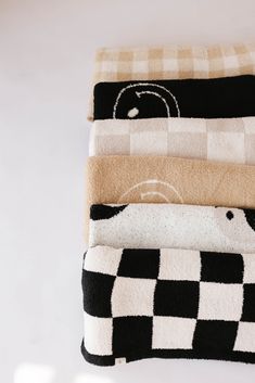 four towels stacked on top of each other in different colors and patterns, one with a bear