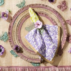 two napkins on a table with purple flowers