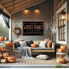 a porch decorated for halloween with pumpkins on the porch and witches market sign above it