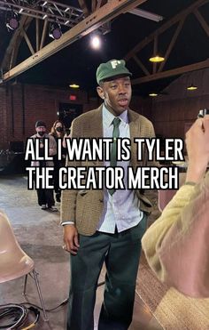 a man in a suit and tie standing next to a chair with the caption, all i want is tyler the creator merch