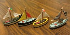 four toy boats are sitting on a wooden table