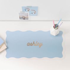 a desk with an assortment of office supplies on top of it, including pens and photos