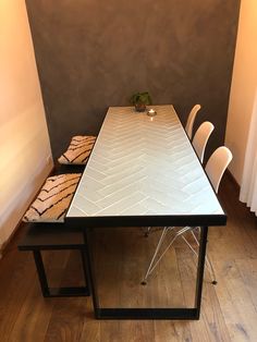 a dining table with two chairs next to it on top of a hard wood floor