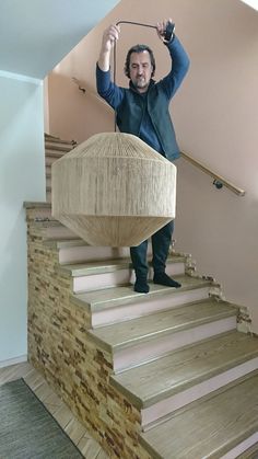 a man standing on top of a set of stairs holding an object in the air