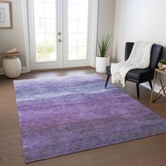 a living room with a purple rug on the floor and a black chair in front of it