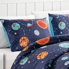 a bed with space themed sheets and pillows