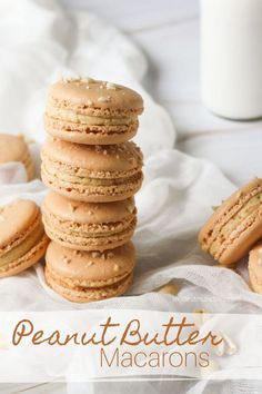 a stack of peanut butter macaroons sitting on top of a white cloth next to a glass of milk