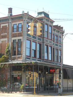 an old brick building on the corner of a street in front of a traffic light