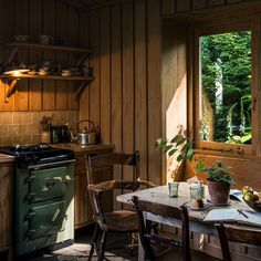 a kitchen with an old fashioned stove and table in the center, next to a window