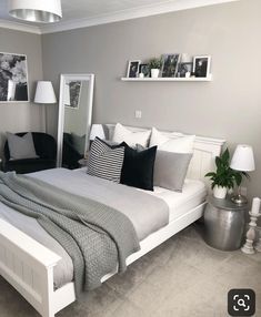 a bedroom with gray walls and white furniture