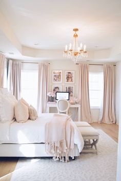 a bedroom with a bed, chandelier and pictures on the wall