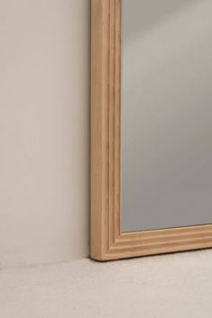 a mirror sitting on the side of a wall next to a white wall and floor