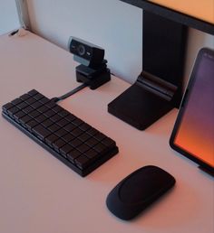 a computer desk with a keyboard, mouse and cell phone on it's side