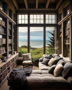 a living room filled with lots of furniture and bookshelves next to a large window