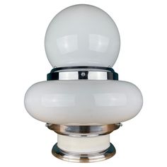 a close up of a light on a white surface with a black base and silver trim