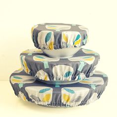 three bowls are stacked on top of each other in front of a white background with blue and yellow designs