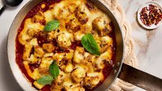 a pan filled with pasta and sauce on top of a table