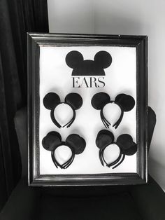 four pairs of mickey ears are in a shadow box with the word ears on it