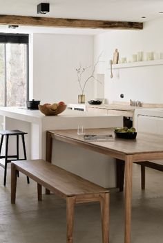 a wooden table sitting next to a white kitchen