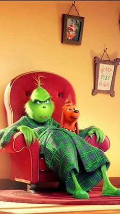 the grinch is sitting in a red chair with his feet up and legs crossed