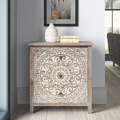 an ornate wooden cabinet in the corner of a room with a painting on the wall