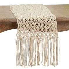 the table runner is made from yarn and has fringes on each side, along with tassels