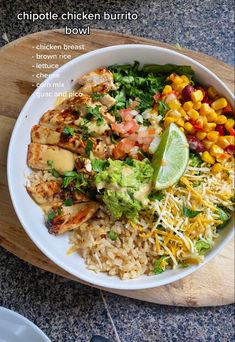 a white bowl filled with rice, chicken and veggies on top of a wooden cutting board