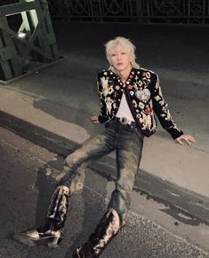 a woman with blonde hair and black boots laying on the ground