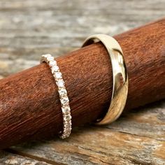 a close up of a ring on top of a piece of wood with a wooden stick in the background