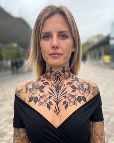 a woman with tattoos on her neck and chest