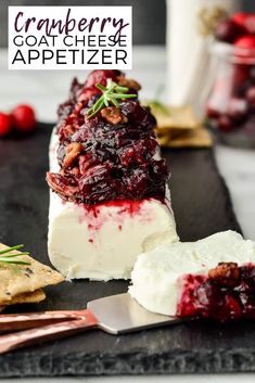 cranberry goat cheese appetizer on a black slate with crackers and berries in the background