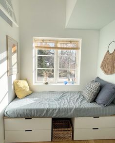 a bedroom with a bed, window and storage drawers