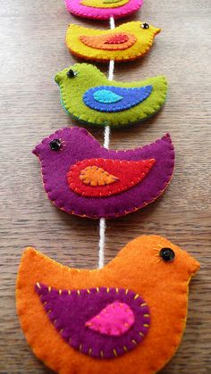 colorful felt birds are lined up on a table