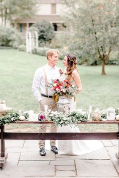 a bride and groom standing in front of a table with flowers