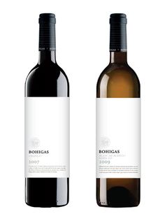 two bottles of wine sitting next to each other on a white surface with no one in it