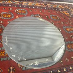 a round mirror sitting on top of a rug