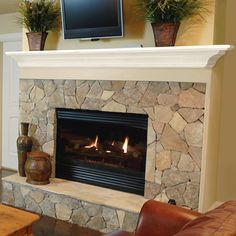 a living room with a stone fireplace and television on the mantel above it's mantle