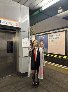 a woman is standing in front of an elevator