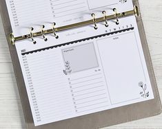 a binder that has some sort of planner attached to it with gold metal handles