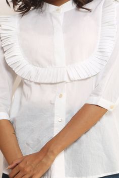 Beautiful white ruffled top, A button down woman's mid length sleeve top with mandarin collar and pleated round frill front yoke. Made from organic cotton which is hand-spun and handwoven by local rural artisans of India. The fabric is soft and breathable , making it perfect for the summer season. This shirt blouse is a versatile piece which can fit well for your formal as well as casual style.  The top can be styled with colourful culottes, (avaliable in our store)  pencil skirt, fitted trouser Chic Summer Blouse With Ruffled Collar, Cotton Blouse With Pleated Sleeves For Daywear, Classic Cotton Tops With Pleated Sleeves, Chic Summer Blouse With Collared Neckline, Elegant White Tops With Ruffle Hem, Fitted Pleated Top For Day Out, Classic Fitted Tops With Pleated Sleeves, Elegant White Top With Ruffle Hem, Casual Pleated Tops For Daywear