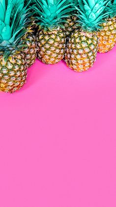 three pineapples on a pink background with green leaves and blue tips in the middle