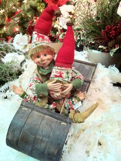 an elf sitting on top of a wooden barrel