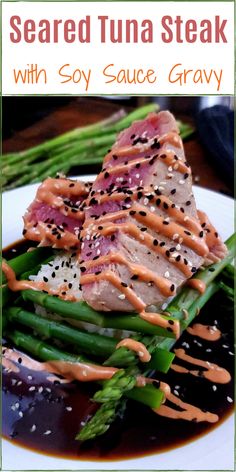 a white plate topped with asparagus and tuna