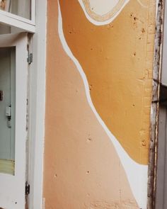 an orange and white painted wall next to a door