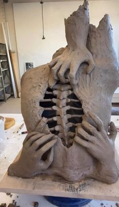 a sculpture is being made in the shape of a human head with hands on it