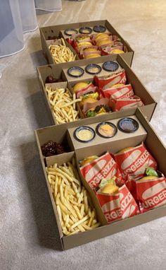 three boxes filled with different types of food sitting on the floor next to each other