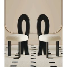 two chairs sitting side by side in front of a wall with black and white stripes