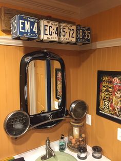 a bathroom sink with a mirror and two license plates above it