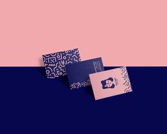 two business cards sitting next to each other on top of a blue and pink background