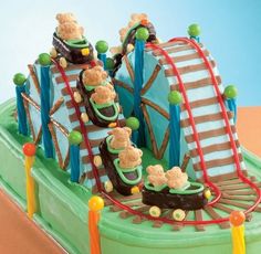 a cake shaped like a train with teddy bears riding on it's tracks and going down the track